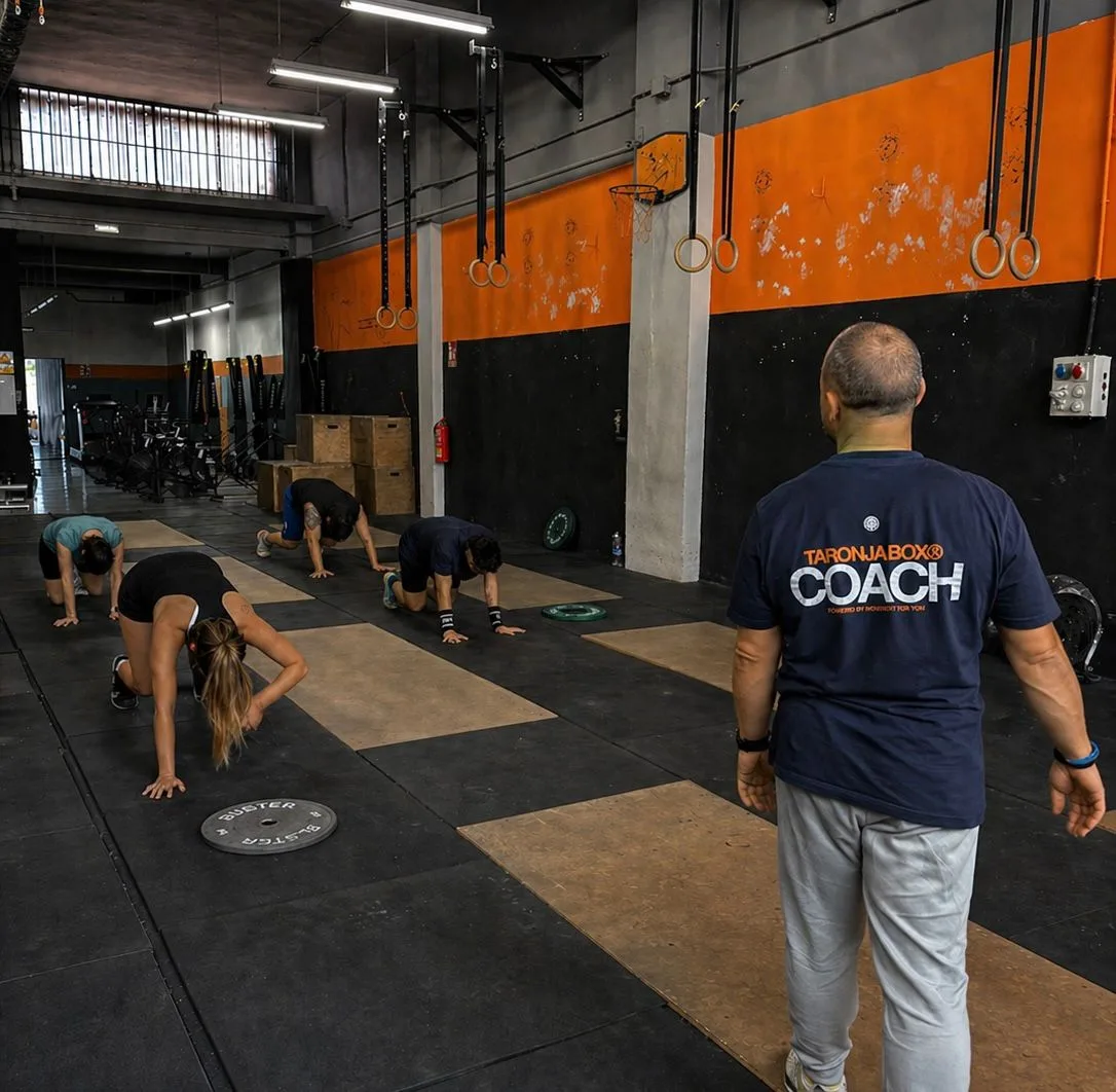 Coach de Taronja Box dirigiendo clase de CrossFit con burpees en Valencia